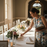Wedding coordinator arranging reception table decor