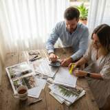Couple planning wedding budget at kitchen table