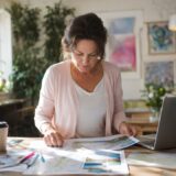 Woman planning travel itinerary at home desk