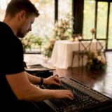 Technical professional adjusting AV equipment in venue
